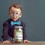 Little boy with money jar